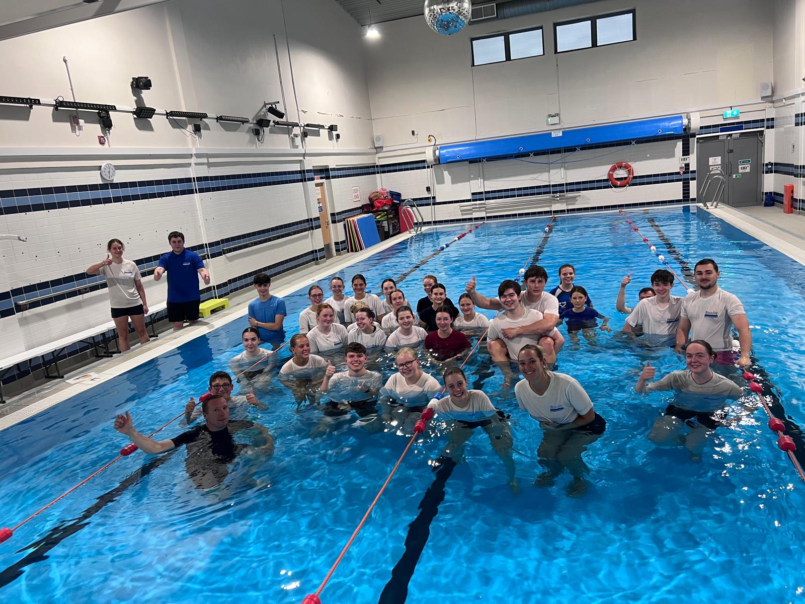 SwimEasy swimming instructors posing together in the pool giving thumbs up after a curriculum standardisation training session.