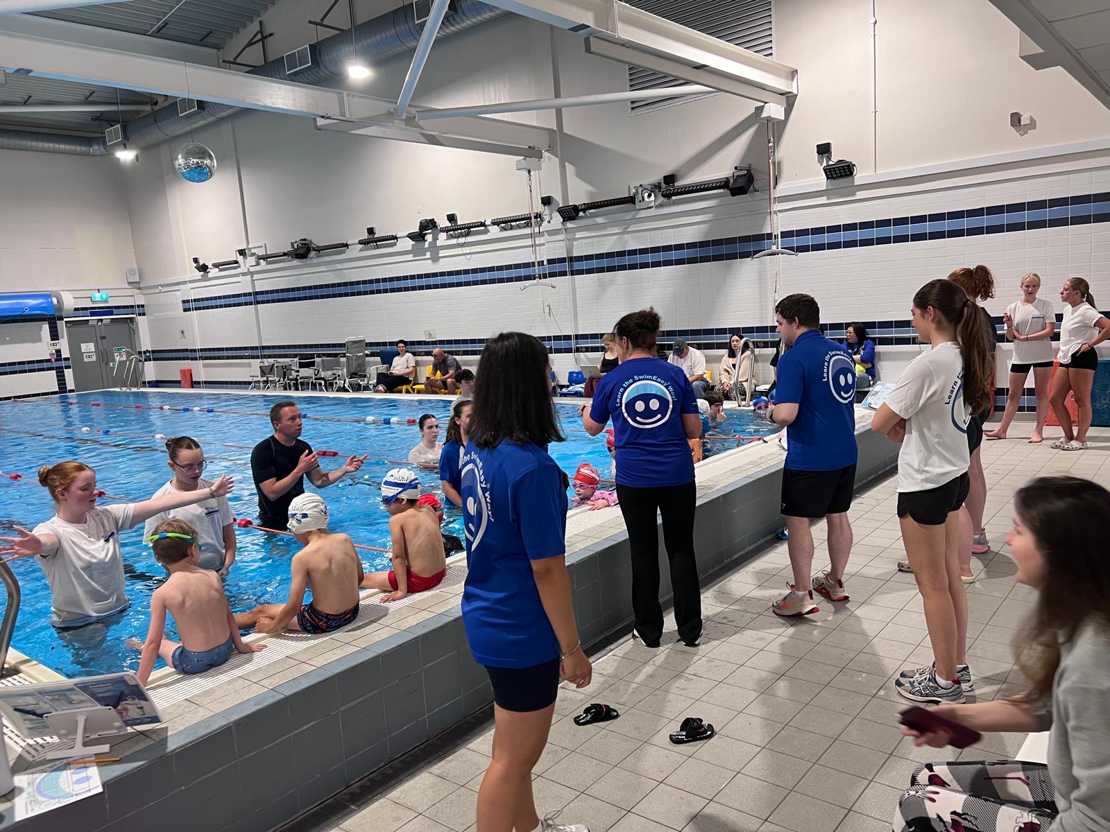 SwimEasy swimming instructors, parents, and children collaborating during a swimming lesson standardisation day poolside